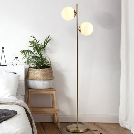 2-globe floor lamp, 65 in, gold — two white glass globe shades on a slim gold-tone pole with a round gold base, in a bedroom