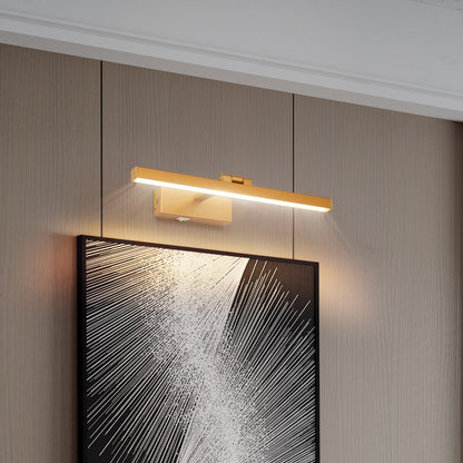 Kingsley rechargeable vanity light in gold with a frosted acrylic diffuser, mounted on a wall above framed art