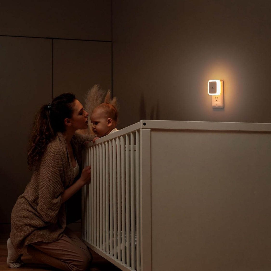 White plug-in dusk to dawn LED night light in a wall outlet, alternate view 1