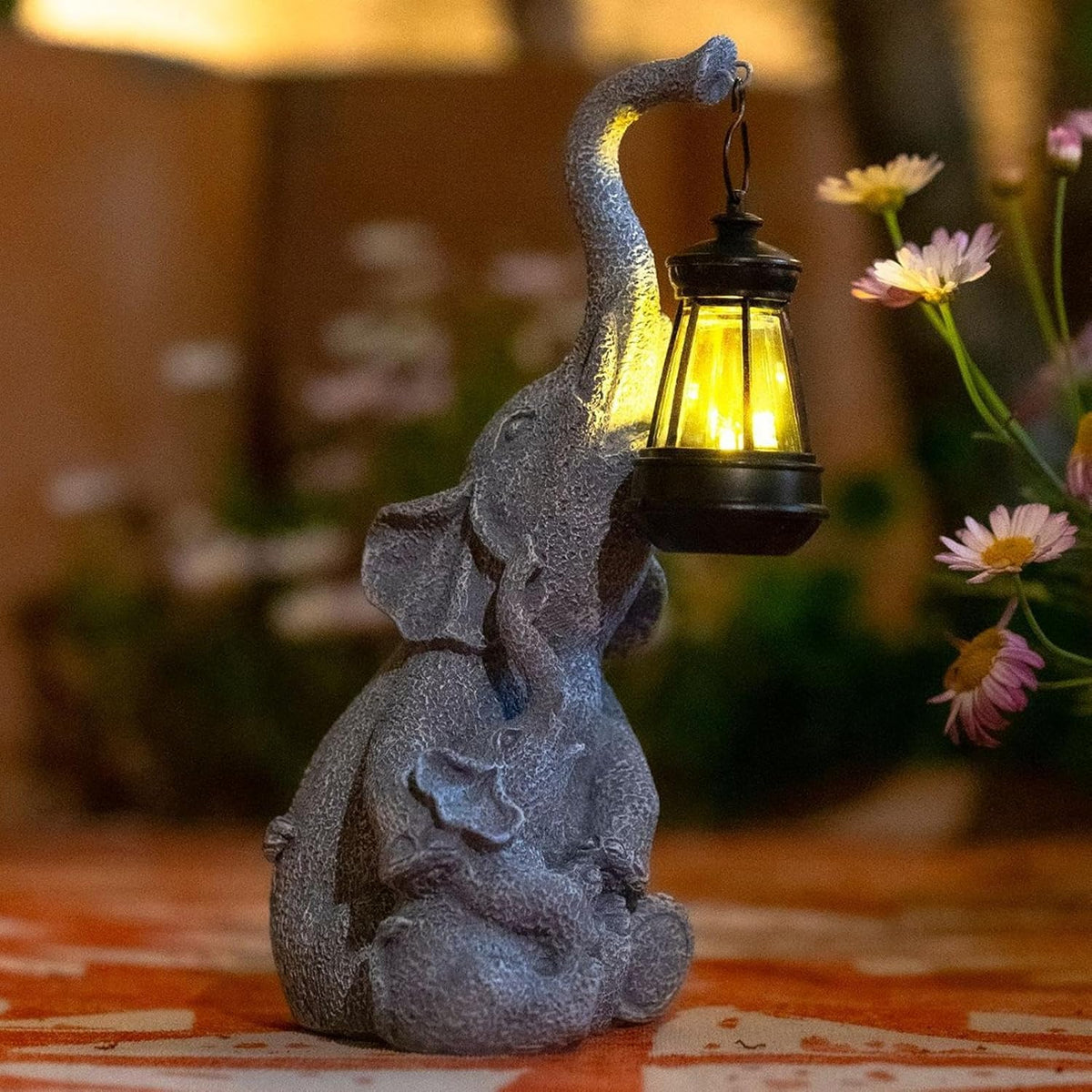 Solar elephant lantern light — a hand-painted grey resin elephant holding a lit lantern in its trunk