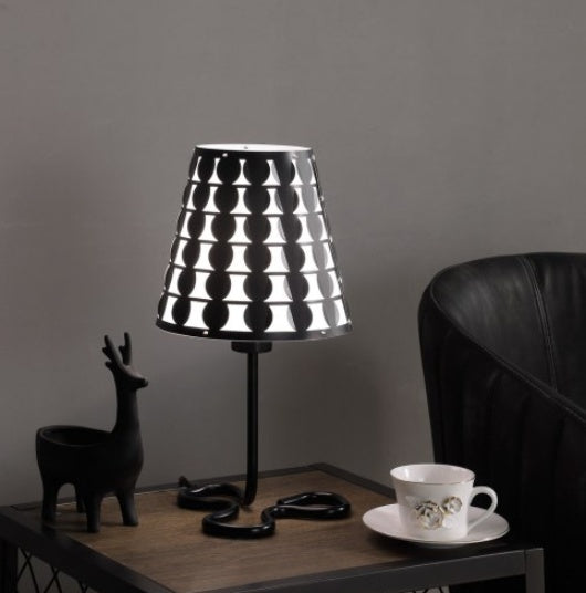 Black geometric table lamp with circle-pattern empire shade on a curving metal clover base