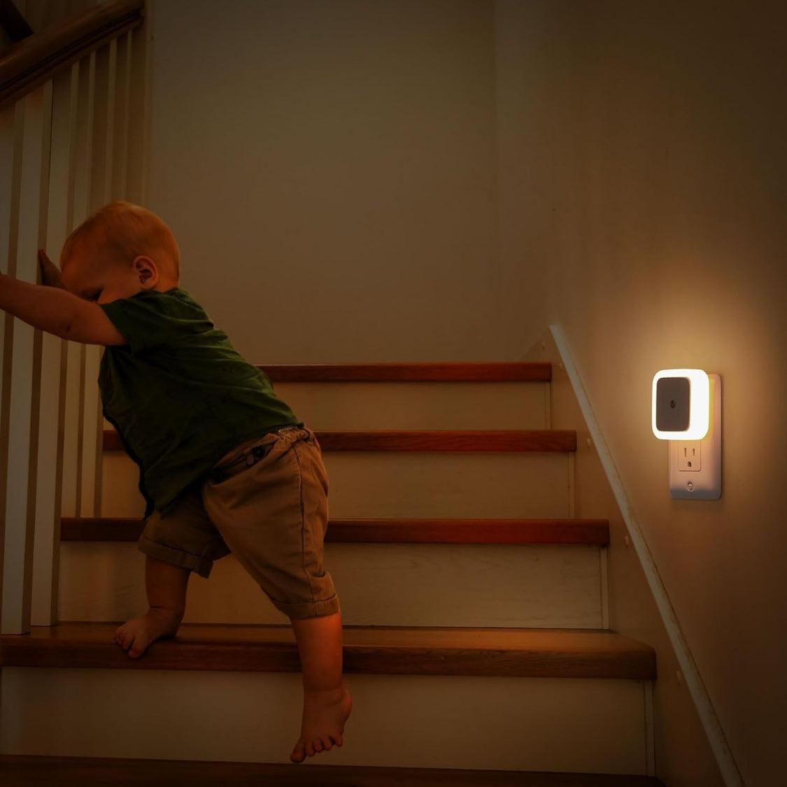 White plug-in dusk to dawn LED night light in a wall outlet, alternate view 2