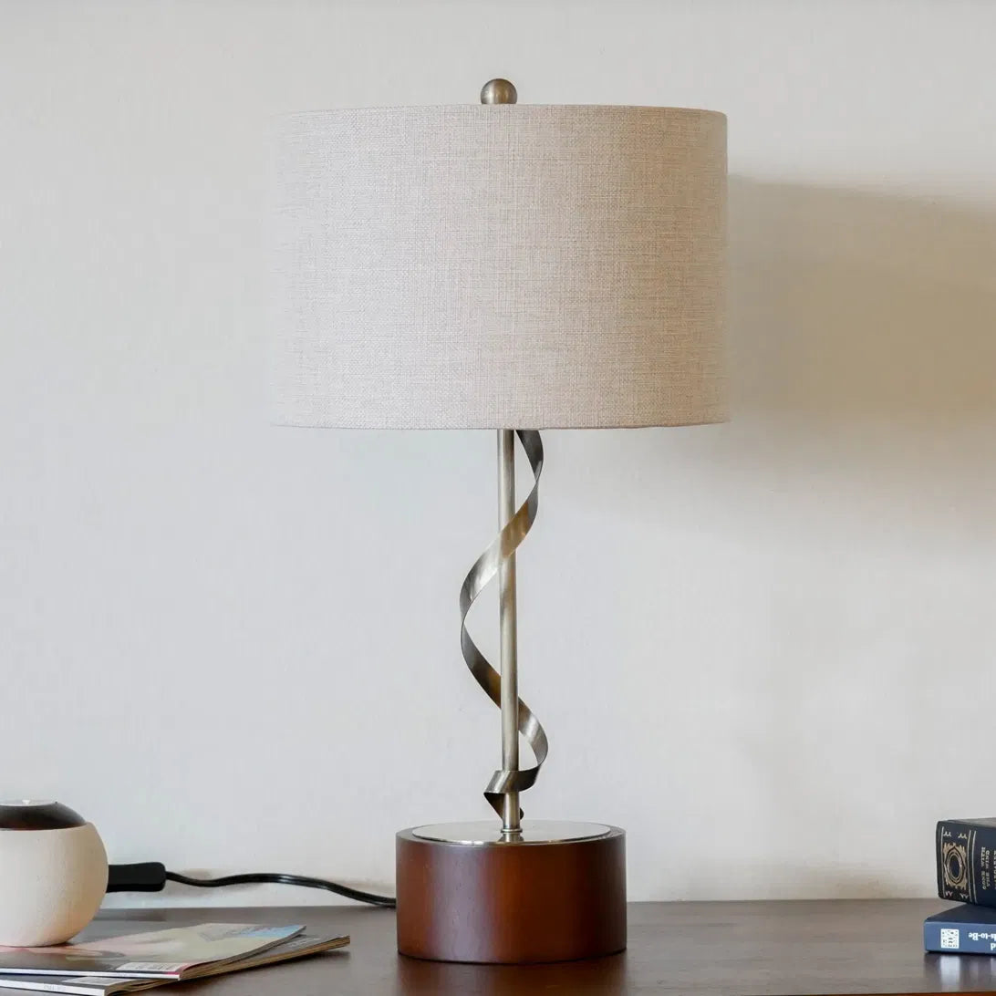 Wexford table lamp with twisted metal stem on a walnut-finish wood base under a white linen cylinder shade